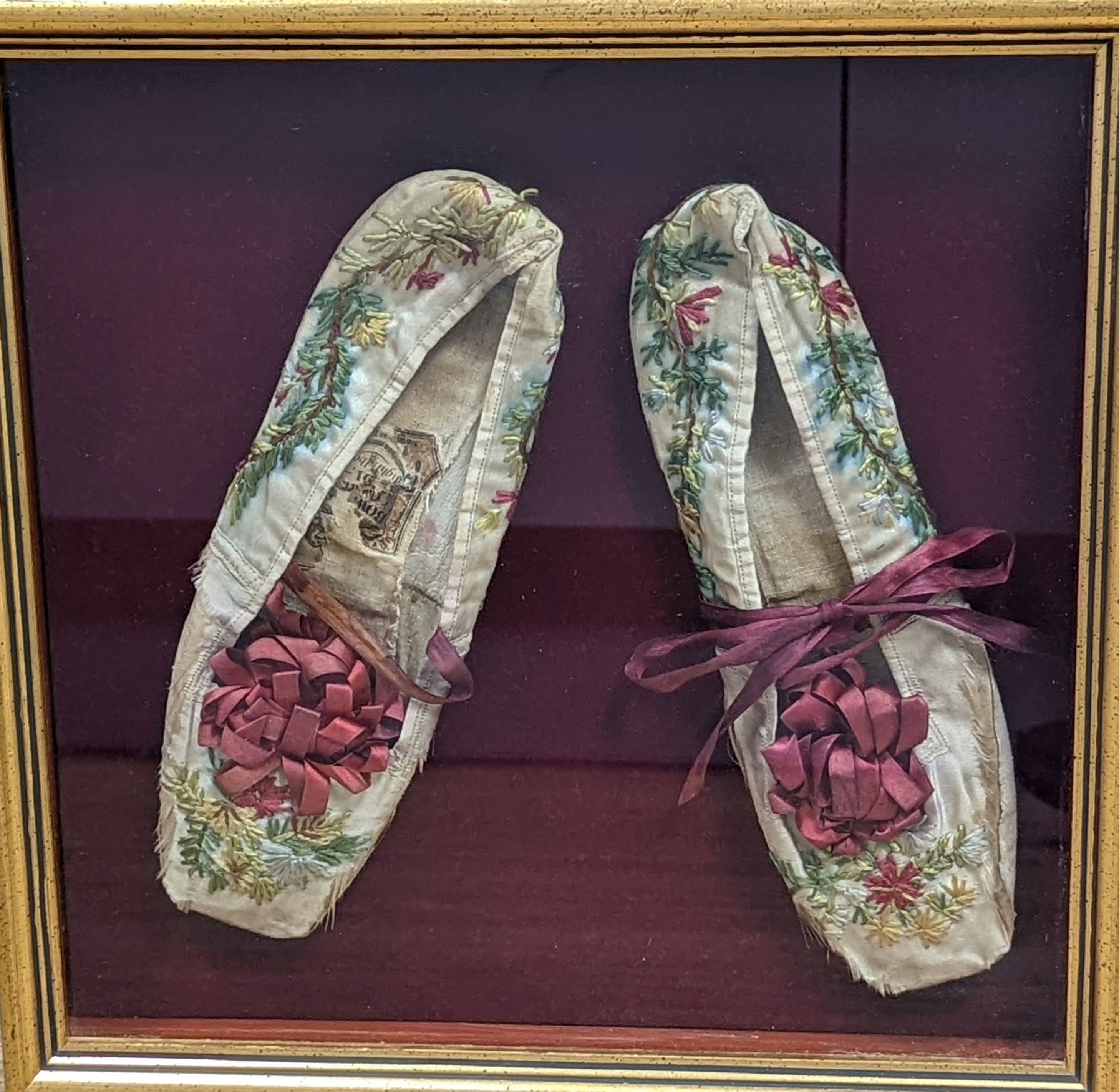 A framed pair of Regency embroidered slippers